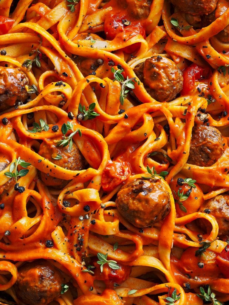 macro food photography of tagliatelle pasta with meatballs and tomato sauce