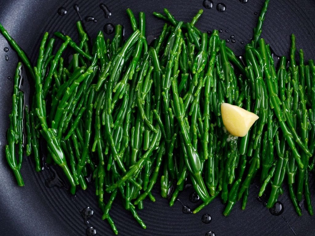 Personal shot of samphire being cooked with melting butter.