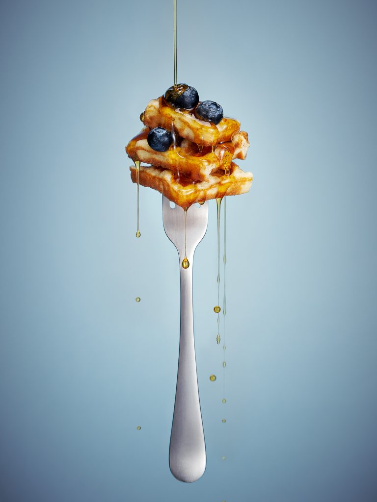 waffles blueberries maple syrup dripping on fork